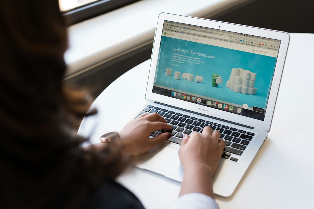 personne travaillant sur un ordinateur portable, mains sur le clavier