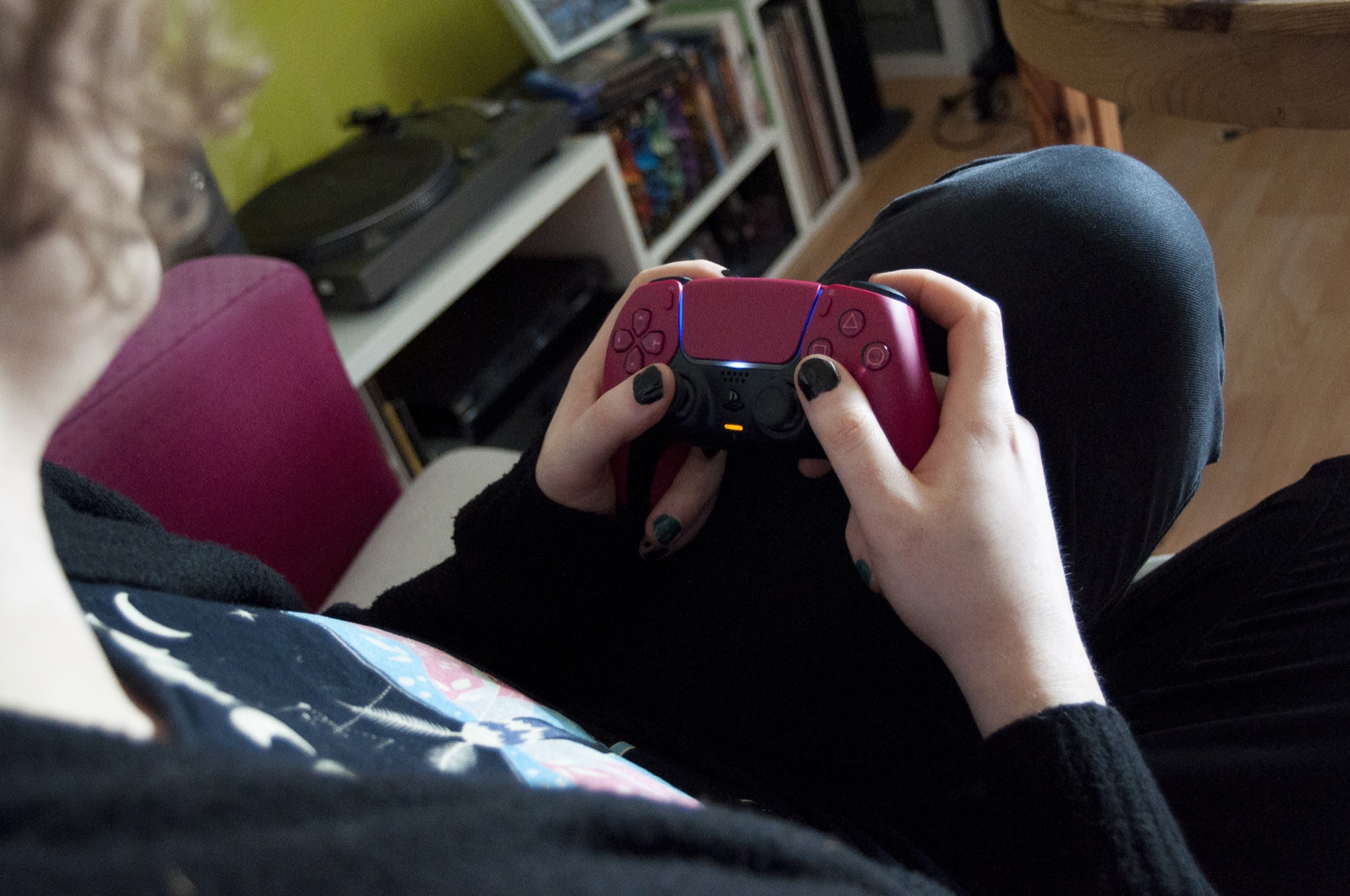 joueur tenant une manette PlayStation 5 DualSense, en train de jouer