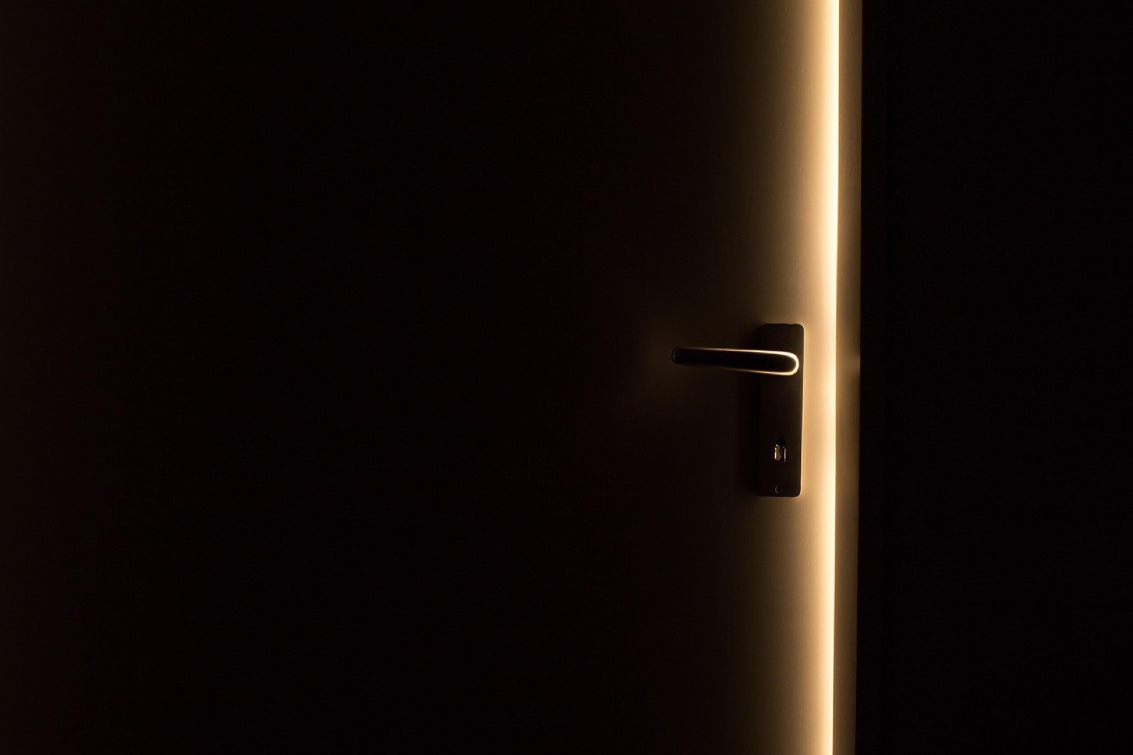 Main qui prend la mesure d'une ouverture de porte intérieure au mètre ruban près de la poignée