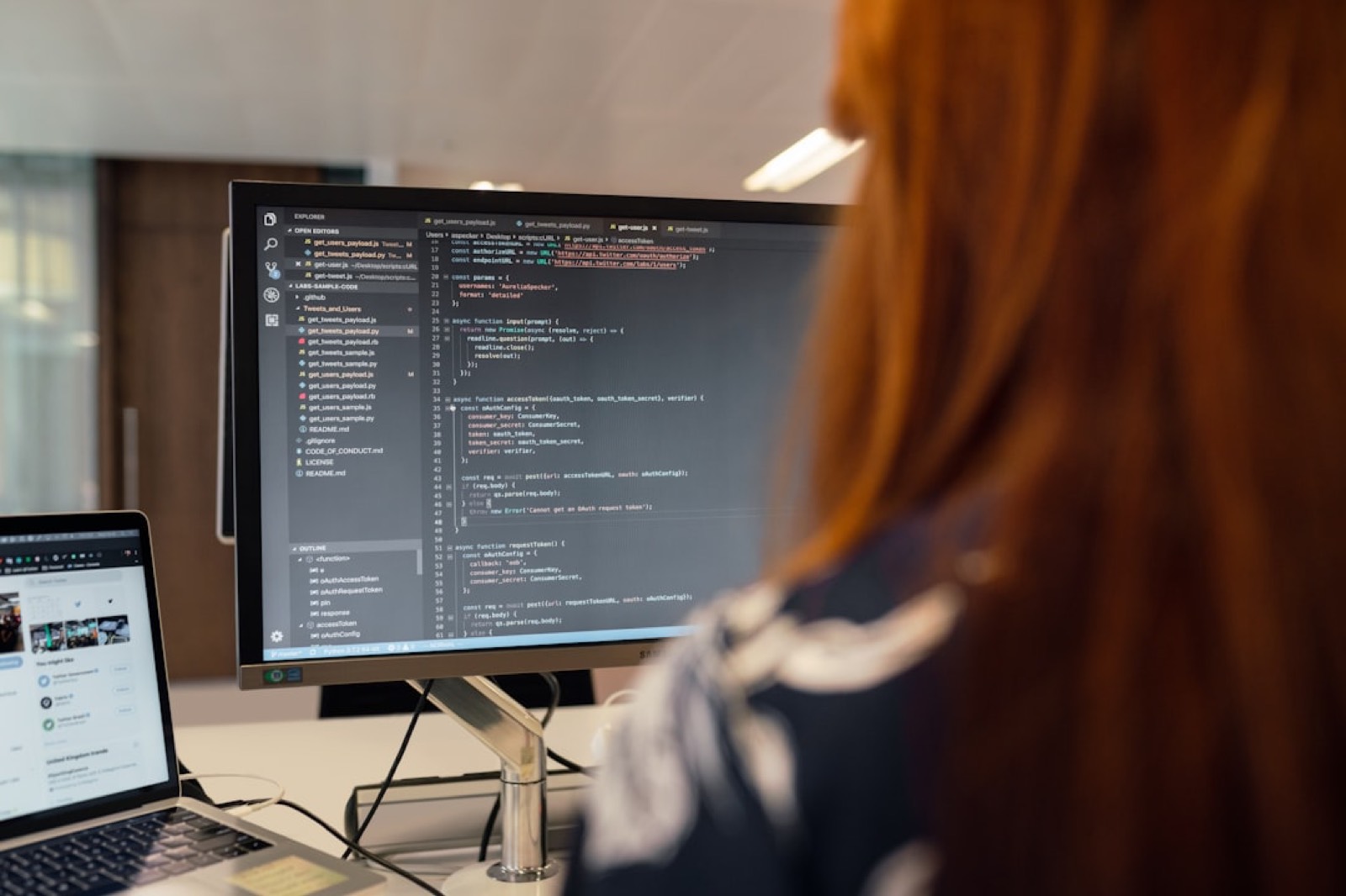 Développeuse relisant du code affiché sur un écran