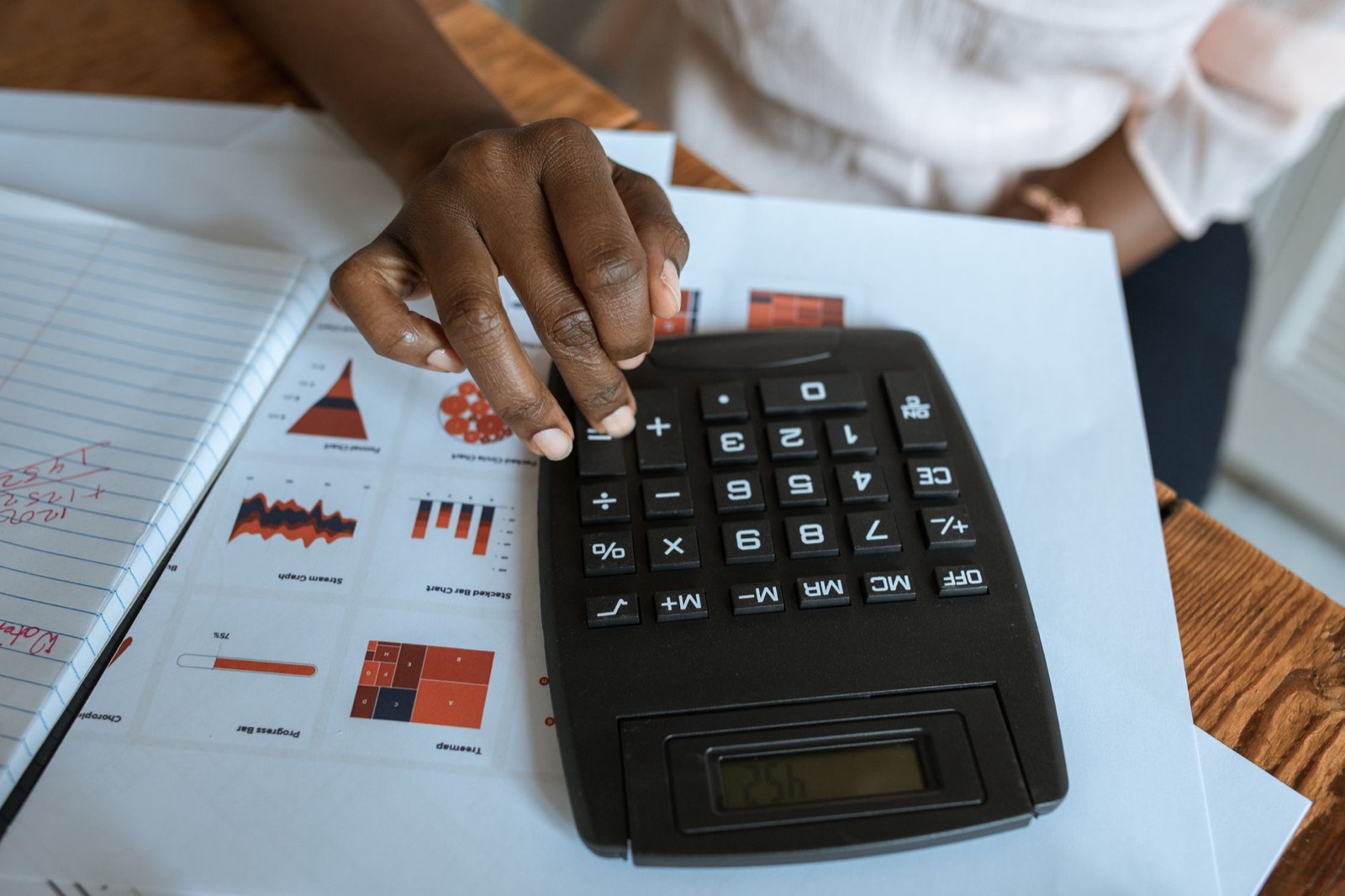 Calculatrice et factures sur un bureau pour évaluer le budget d'un tournage drone municipal