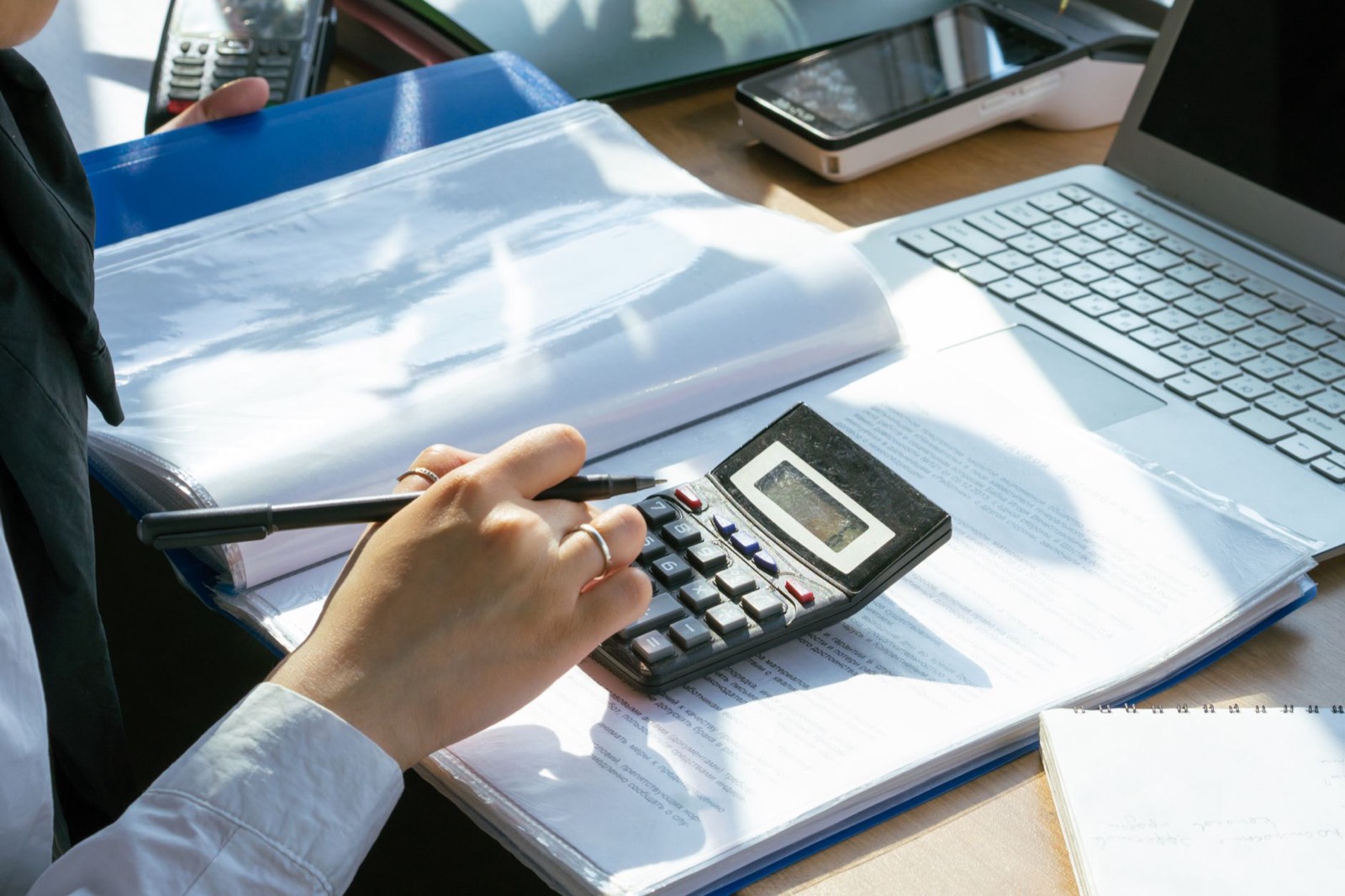 Personne qui calcule un budget sur un bureau avec factures et calculatrice