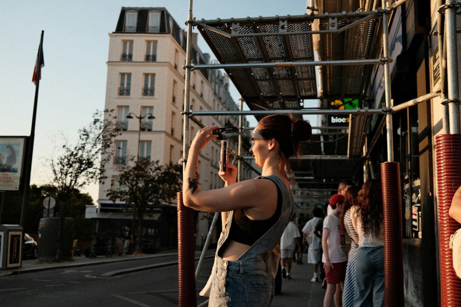 personne filmant une scène de rue avec son smartphone