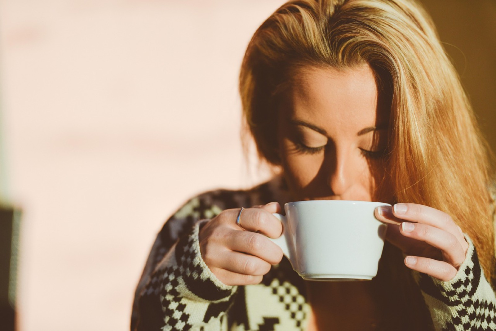 Une personne consulte son téléphone devant un café le matin, le moment habituel de la partie de mots du jour