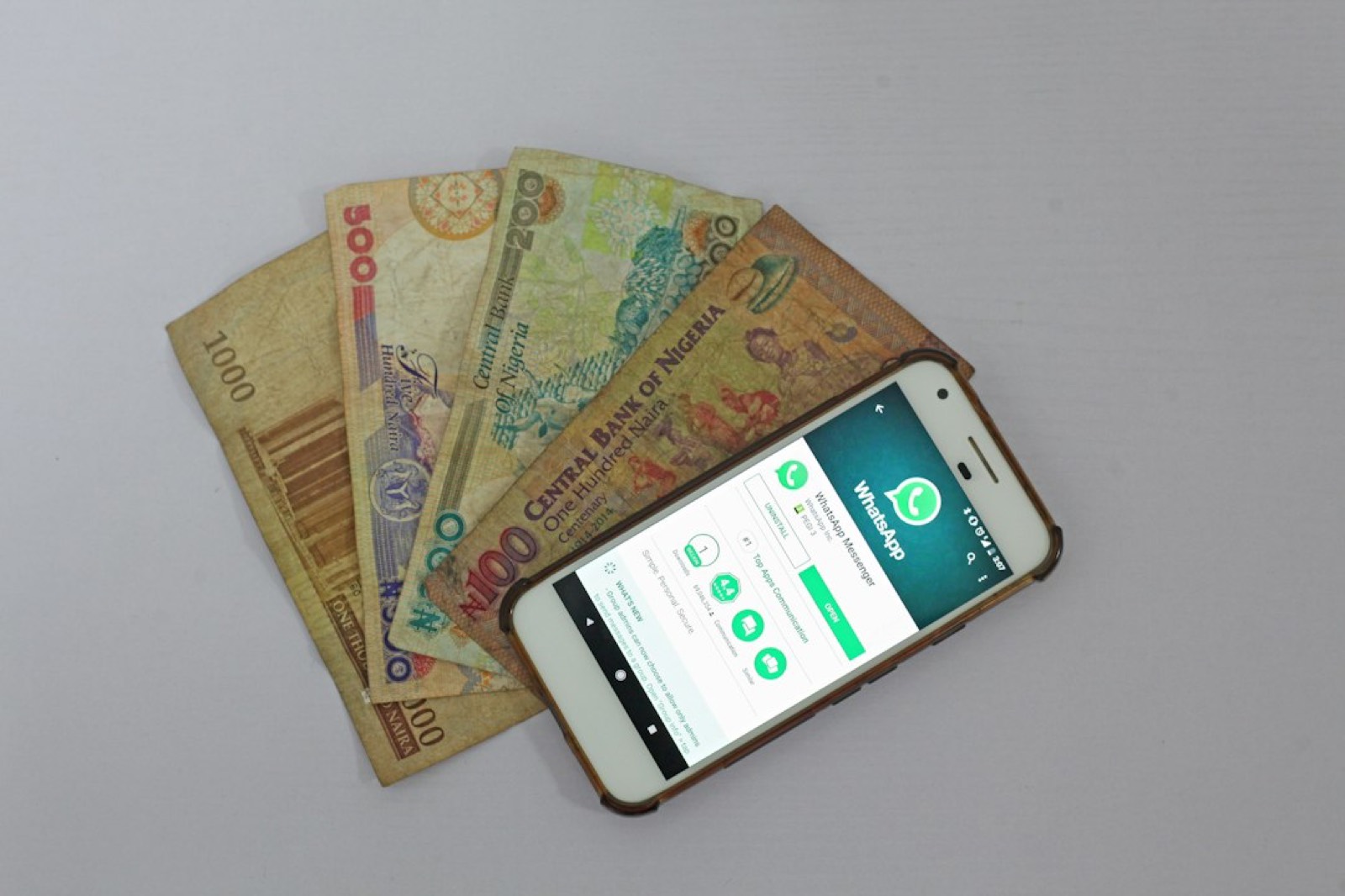 Smartphone, portefeuille et billets, pour illustrer l'argent réellement retiré après la vente d'un skin